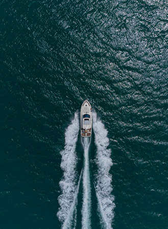 Aerial top down view of speed motor boat on open sea at summer dayの写真素材