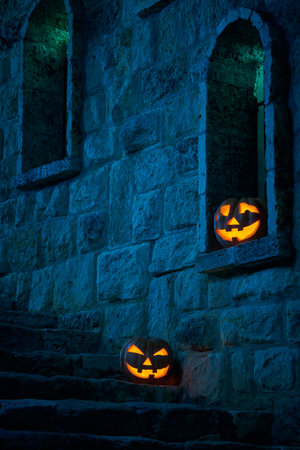 Halloween pumpkins jack p lantern in the yard of an old castle at night in the bright moonlightの写真素材
