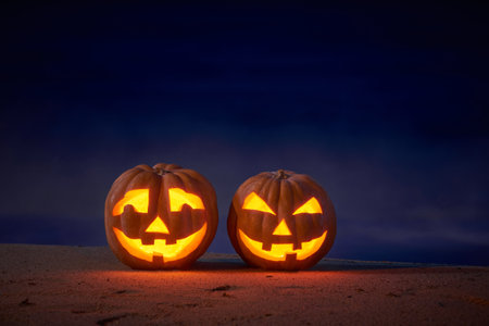 Halloween pumpkins jack p lantern on the sea beach at night in the bright moonlightの写真素材