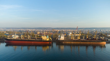 Aerial view of big cargo ship bulk carrier is loaded with grain of wheat in port at sunsetの写真素材