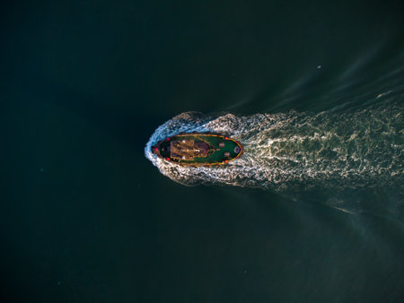 Aerial drone view of industrial tug assisting boat in deep seaの写真素材