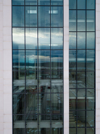 Business district office building with wall mirror with cloudy sky