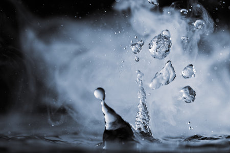 Boiling water splash with steam on black background close-upの写真素材