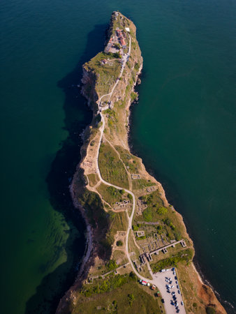 aerial top view of Cape Kaliakra, Bulgaria's enchanting headland. Marvel at the majestic cliffs, ancient fortress, and panoramic sea vistas that make this coastal gem truly captivatingの写真素材