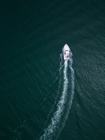 Aerial top down view of speed motor boat on open sea at summer day