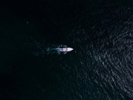 Aerial view of a pleasure boat racing through the sea waves, creating a mesmerizing picture of speed and freedom.の写真素材