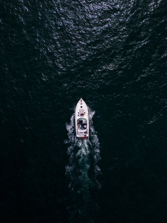 Aerial view of a pleasure boat racing through the sea waves, creating a mesmerizing picture of speed and freedom.の写真素材
