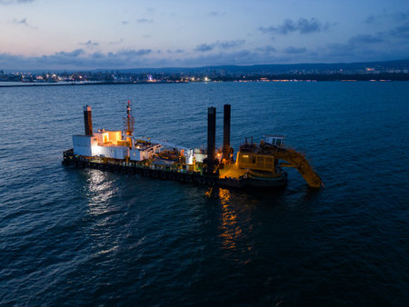 Aerial view of a dredge vessel with a dredging bucket, actively deepening the navigational fairway at sea, ensuring safe navigation.の写真素材