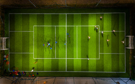 An aerial view of an evening sports ground with soccer and basketball fields, where children are practicing football and basketball.の写真素材