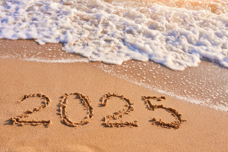 2025 year drawing on sandy beach sea at sunny dayの写真素材