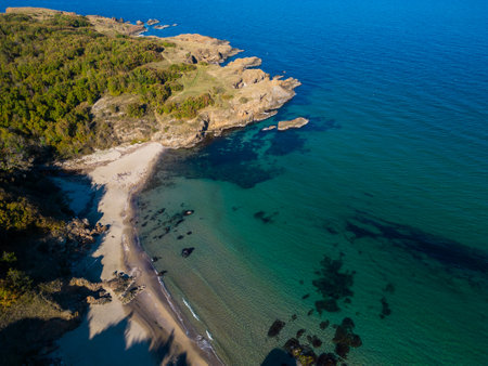 Aerial view of the rocky, wild coast of the Black Sea in Bulgaria, with cliffs, beaches, and green forestsの写真素材