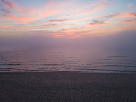 Aerial view of a sunrise sea with a blanket of morning fog and morning sunbeams shining throughの写真素材