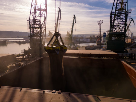 Aerial view of big cargo ship bulk carrier is loaded with grain of wheat in port at sunset.の写真素材