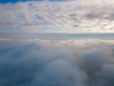 A drone flies over fluffy clouds. The drone flies through the clouds, creating a sense of wonder and awe.の写真素材