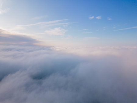 A drone flies over fluffy clouds. The drone flies through the clouds, creating a sense of wonder and awe.の写真素材