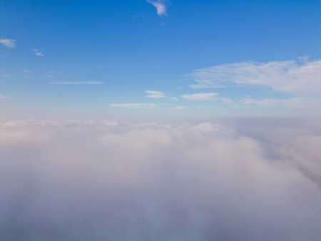 A drone flies over fluffy clouds. The drone flies through the clouds, creating a sense of wonder and awe.の写真素材