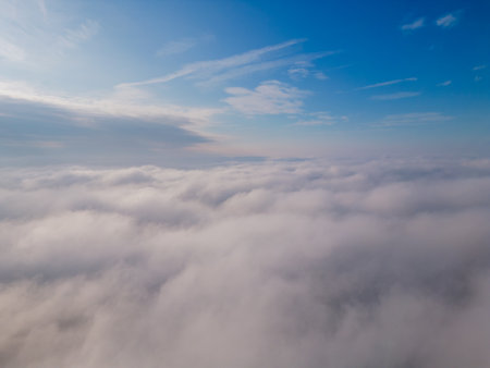 A drone flies over fluffy clouds. The drone flies through the clouds, creating a sense of wonder and awe.の写真素材