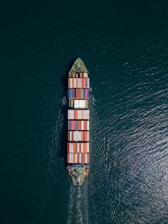 A container ship moves steadily through the ocean, carrying stacked containersの写真素材