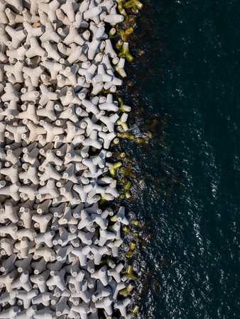 Aerial drone view of a breakwater. breakwater in the sea, a collection of concrete tetrapod breakersの写真素材