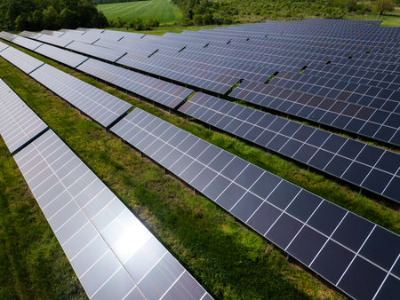 drone view of a solar power station next to a forest during summer. Renewable energy meets nature in...