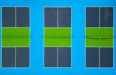 Aerial view of vibrant pickleball courts with distinct green and blue colors. The geometric layout and bold contrasts create a striking visual. Ideal for sports, recreation, and aerial perspectivesの写真素材