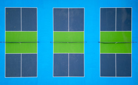 Aerial view of vibrant pickleball courts with distinct green and blue colors. The geometric layout and bold contrasts create a striking visual. Ideal for sports, recreation, and aerial perspectivesの写真素材