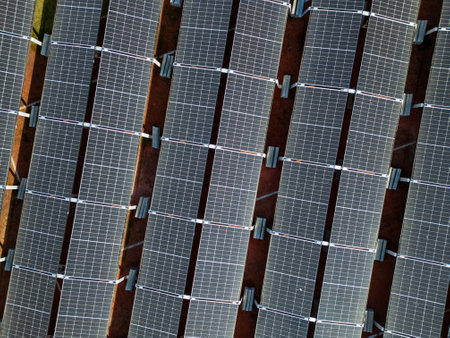 Aerial drone view of solar panels arranged in rows, capturing the geometric pattern of a solar farm, perfect for renewable energy, sustainability, and clean power themesの写真素材