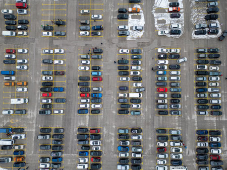 Busy parking lot filled with various vehicles during a cloudy day in an urban area