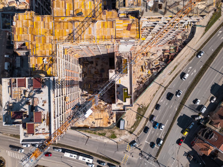 Construction site showcases vibrant materials and equipment under bright sunlight in an urban area. Aerial top down viewの写真素材