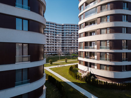 Aerial drone shot of a modern residential building facade with brown panels and white balconies, highlighting clean architectural lines and contemporary urban designの写真素材