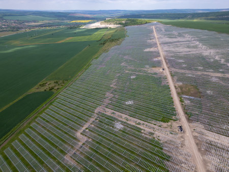 Aerial view of a solar farm under construction with metal mounting structures arranged on a...
