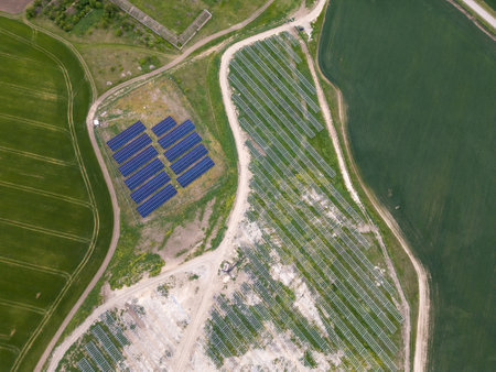 Aerial view of solar panels and mounting structures in a rural area. Part of the solar farm is...