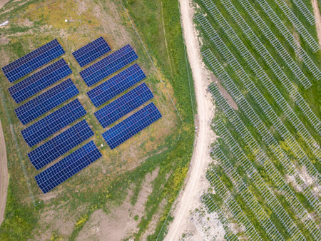 Aerial view of solar panels and mounting structures in a rural area. Part of the solar farm is operational, while the other side is under construction. Renewable energy development conceptの写真素材