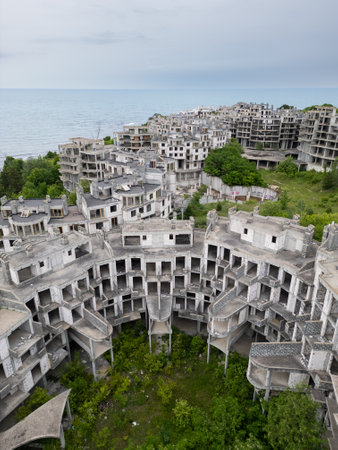 Abandoned hotel complex in Tsarevo, Bulgaria. Aerial view of decaying brutalist buildings overtaken by nature. Urban exploration, urbex, site with eerie, post-apocalyptic atmosphere.の写真素材
