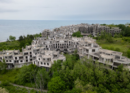 Abandoned hotel complex in Tsarevo, Bulgaria. Aerial view of decaying brutalist buildings overtaken by nature. Urban exploration, urbex, site with eerie, post-apocalyptic atmosphere.の写真素材