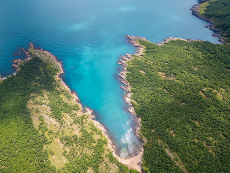 Aerial view of a wild cove surrounded by forest and rocky shores on the Black Sea coast in Bulgaria. Crystal clear turquoise water and untouched natureの写真素材