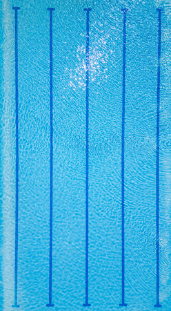Top-down view of an empty swimming pool with lane dividers and clear blue water. Sunny reflections and clean geometry make it perfect for fitness, sports, and summer themesの写真素材