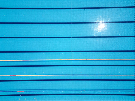 Aerial top-down view of an Olympic-size swimming pool with marked lanes and clear blue water. Symmetrical patterns and clean design ideal for sports, fitness, and summer conceptsの写真素材