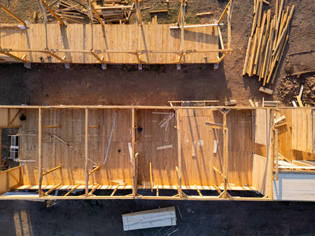 Aerial view of wooden house construction in progress. Framework and walls being built with timber, showing structure and building processの写真素材