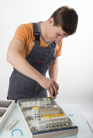 electrical appliance repairs. electrician fixing cable in domestic electrical boxの写真素材