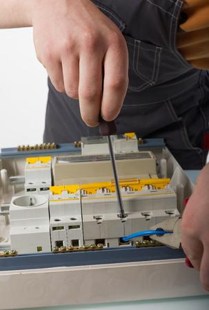 electrical appliance repairs. electrician fixing cable in domestic electrical boxの写真素材