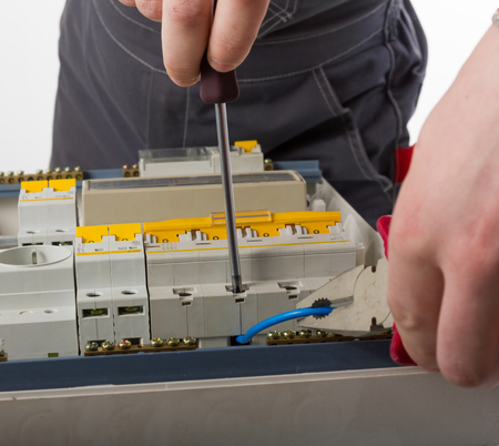 electrical appliance repairs. electrician fixing cable in domestic electrical boxの写真素材