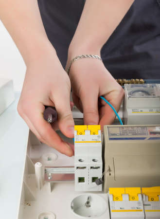 electrical appliance repairs. electrician fixing cable in domestic electrical boxの写真素材