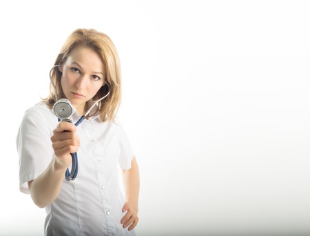 beautiful young female doctor in medical gown holding  phonendoscope.の写真素材