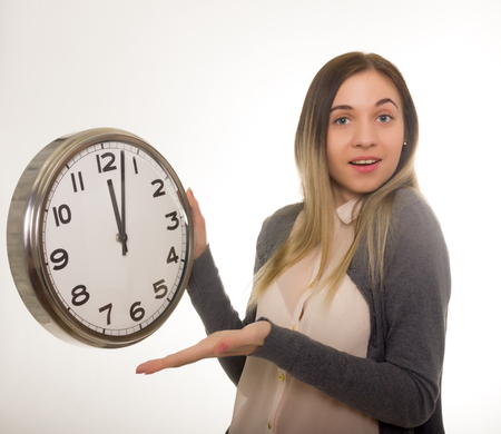 Surprise young woman looking at alarm clock with blank copy space, closeup portrait of beautiful europian woman, positive human emotion facial expressionの写真素材