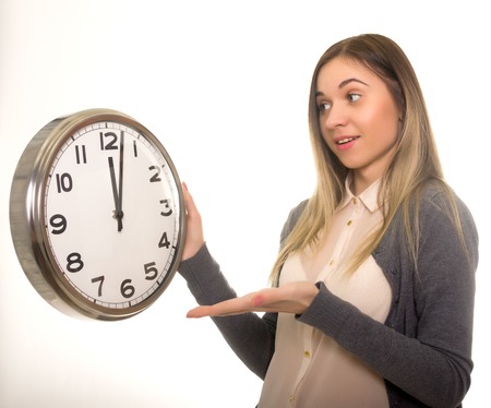 Surprise young woman looking at alarm clock with blank copy space, closeup portrait of beautiful europian woman, positive human emotion facial expressionの写真素材