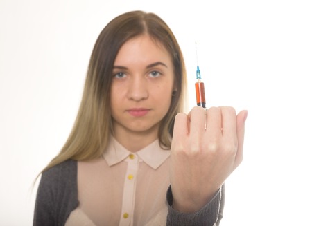 The social problem. Young sad woman holding syringe to drug useの写真素材
