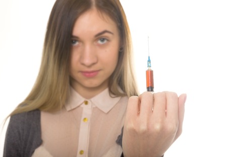 The social problem. Young sad woman holding syringe to drug useの写真素材
