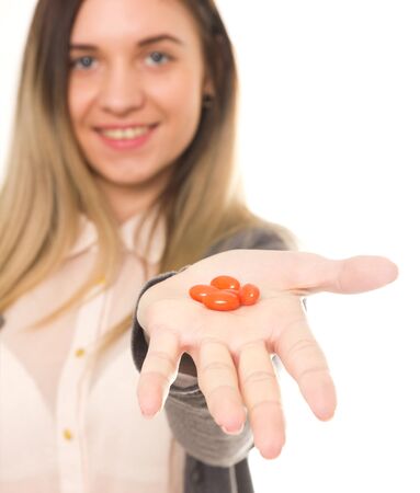 young woman holding the drugs at arm's length. she offers taste of the tabletsの写真素材
