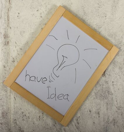 Message board hanging on a grey wall, inscription have ideaの写真素材